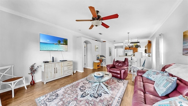 living area featuring light wood-style floors, arched walkways, and crown molding
