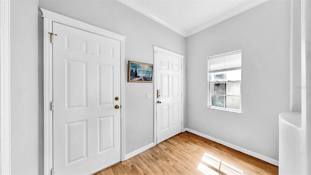 interior space with light wood-style flooring, ornamental molding, and baseboards