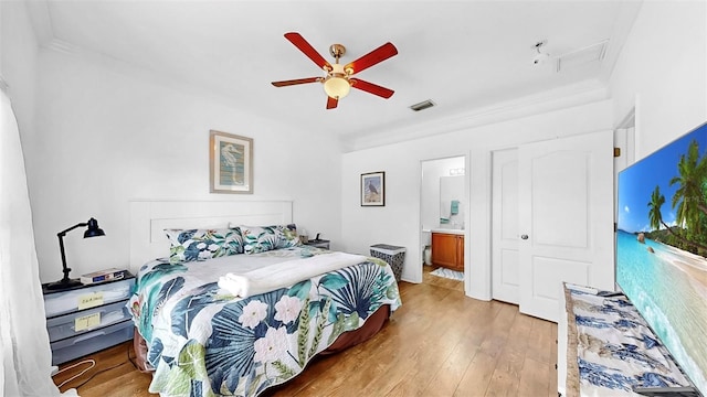 bedroom featuring visible vents, a ceiling fan, ensuite bathroom, crown molding, and light wood-type flooring