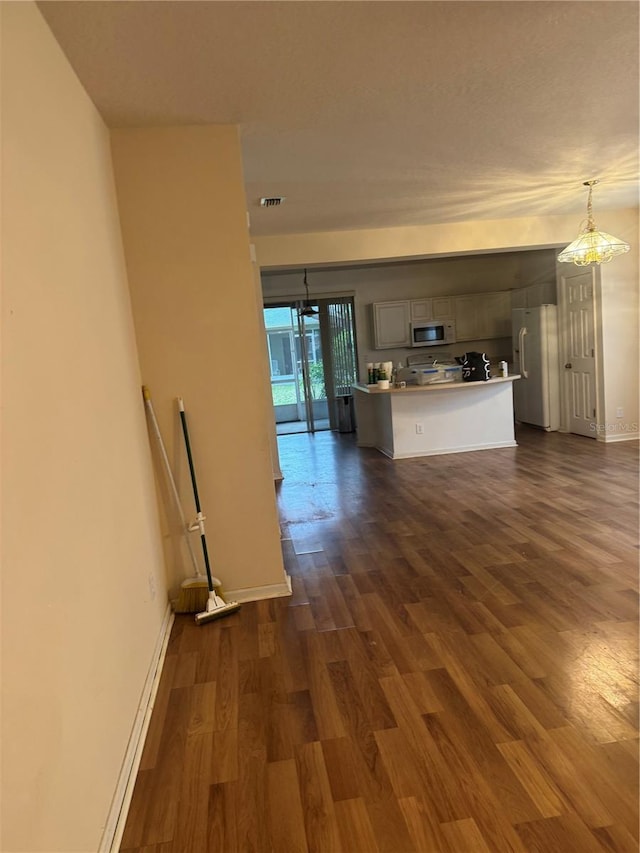 interior space with dark wood finished floors, visible vents, and baseboards