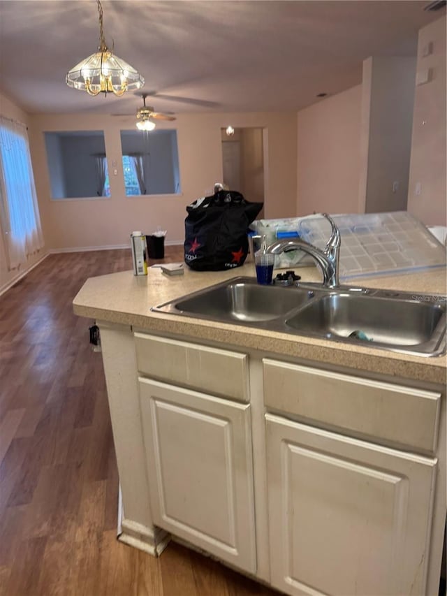 kitchen featuring ceiling fan, wood finished floors, decorative light fixtures, light countertops, and a sink