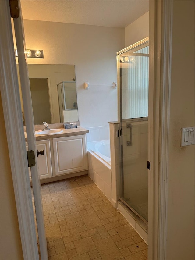 bathroom featuring a garden tub, a shower stall, and vanity