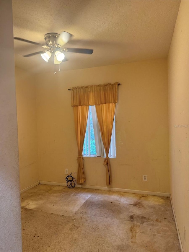 empty room featuring a ceiling fan, carpet flooring, a textured ceiling, and baseboards