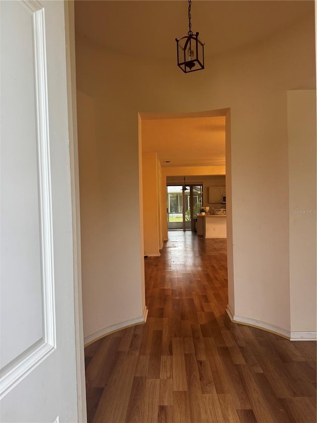 hallway with baseboards and dark wood finished floors