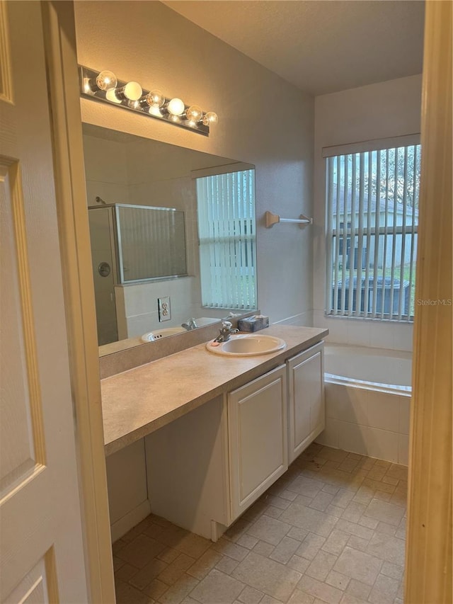 full bath with a garden tub, a shower stall, and vanity