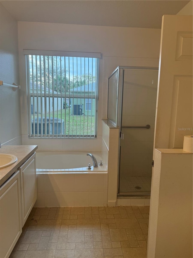 full bath featuring a garden tub, a shower stall, and vanity
