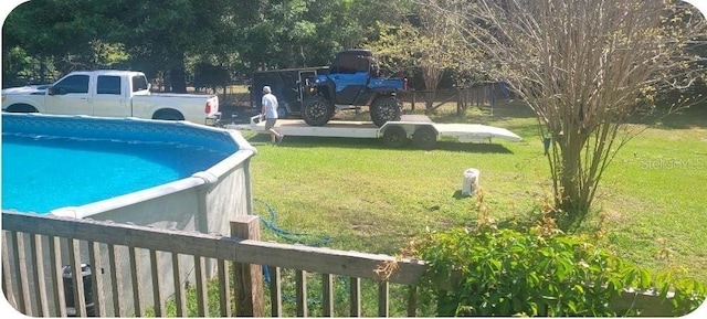 view of pool with a lawn and fence