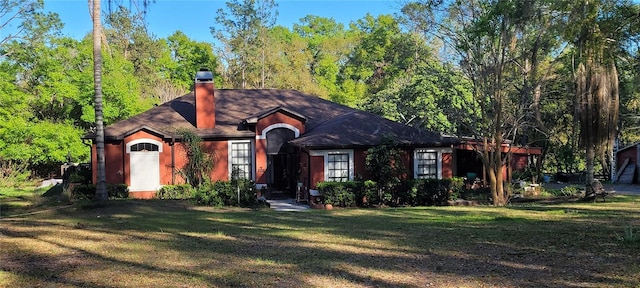 view of front of house featuring a front lawn, stucco siding, and a chimney