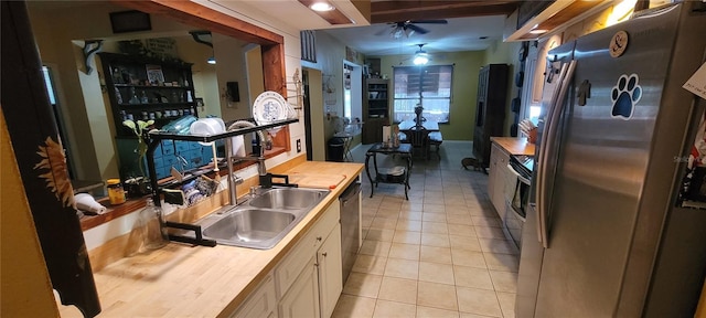 kitchen featuring a sink, wood counters, appliances with stainless steel finishes, light tile patterned flooring, and ceiling fan