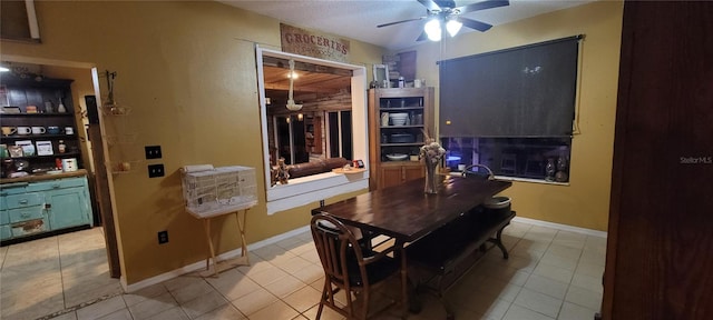 dining room featuring light tile patterned floors, baseboards, and a ceiling fan