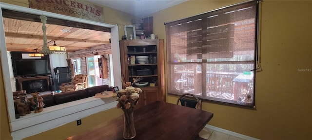 dining area featuring beam ceiling, wooden ceiling, and baseboards