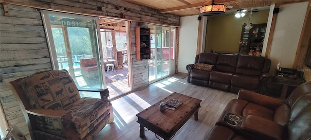 living room with beamed ceiling, wood ceiling, and wood finished floors