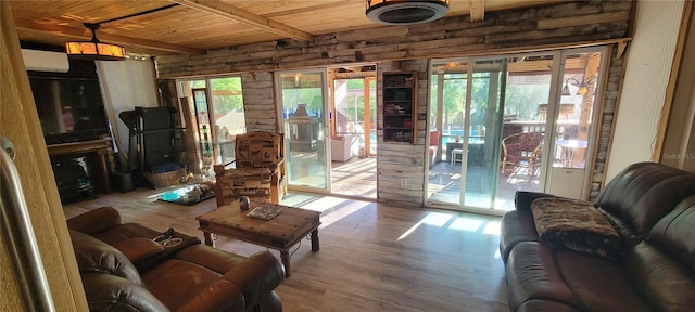 living area with beamed ceiling, plenty of natural light, wood finished floors, and wooden ceiling