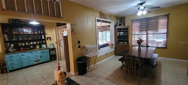 dining space featuring light tile patterned flooring, a textured ceiling, baseboards, and a ceiling fan