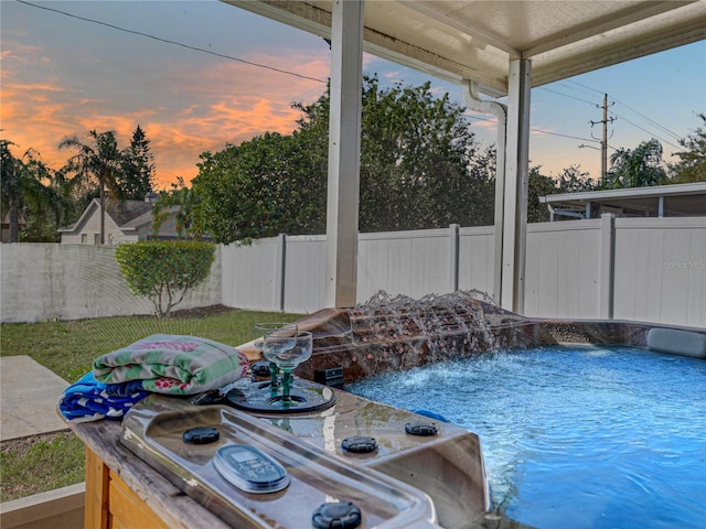 pool at dusk with a swimming pool and a fenced backyard