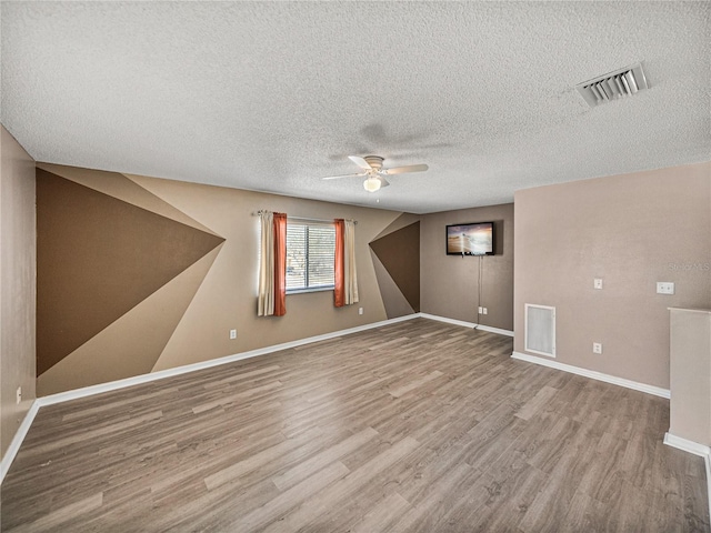 additional living space featuring wood finished floors, visible vents, and baseboards