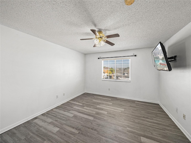 spare room with ceiling fan, a textured ceiling, wood finished floors, and baseboards