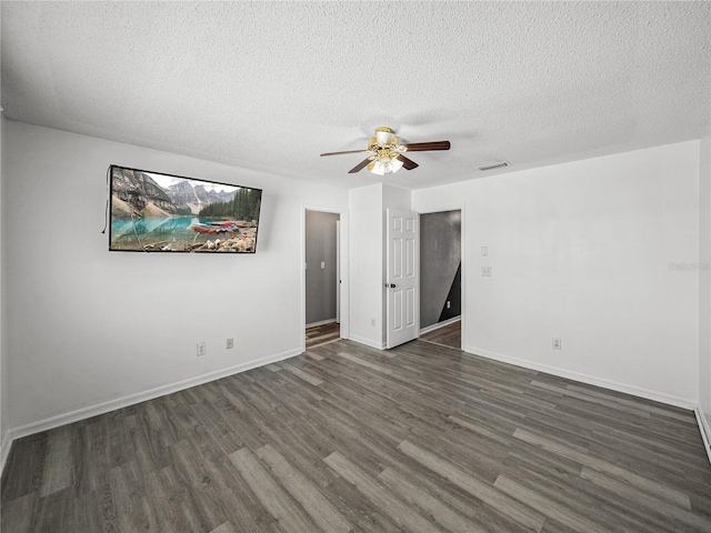 unfurnished room with visible vents, dark wood-type flooring, ceiling fan, a textured ceiling, and baseboards