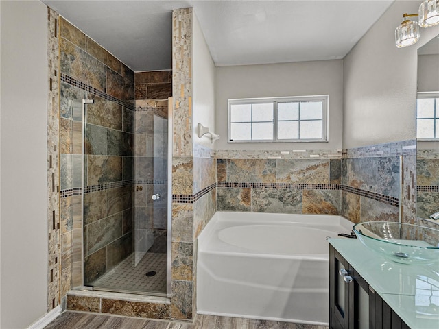 full bathroom with plenty of natural light, a shower stall, a garden tub, and vanity