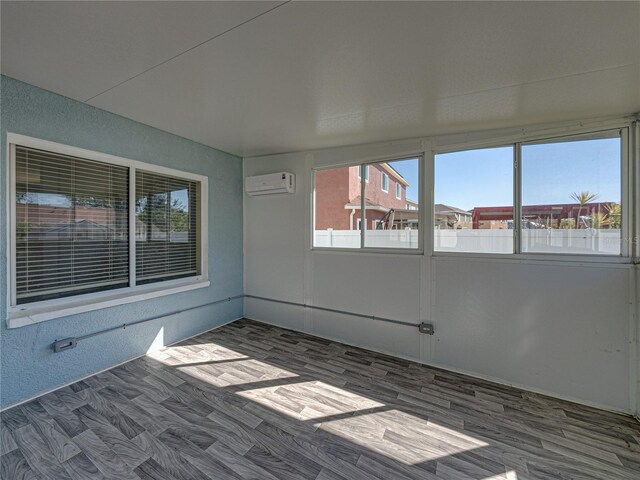 unfurnished sunroom featuring a wall unit AC