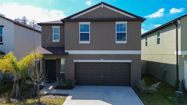 view of front of home with driveway, an attached garage, and stucco siding