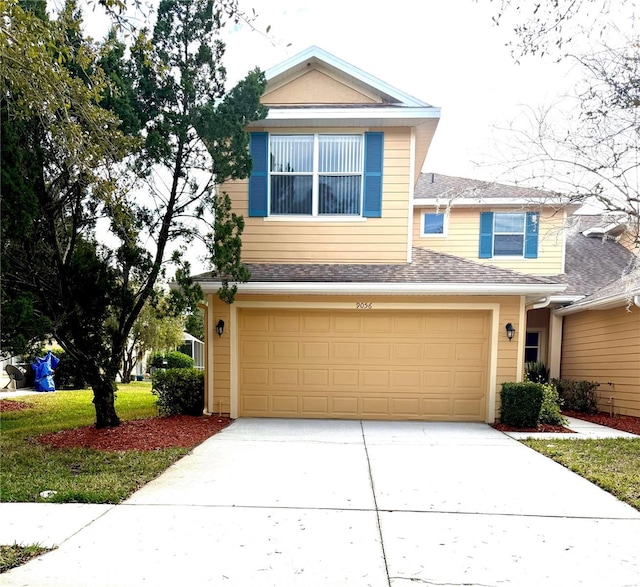 traditional home featuring a garage, concrete driveway, and roof with shingles