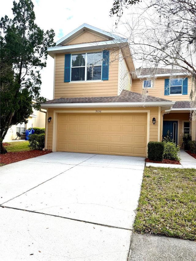 traditional-style home featuring concrete driveway and an attached garage