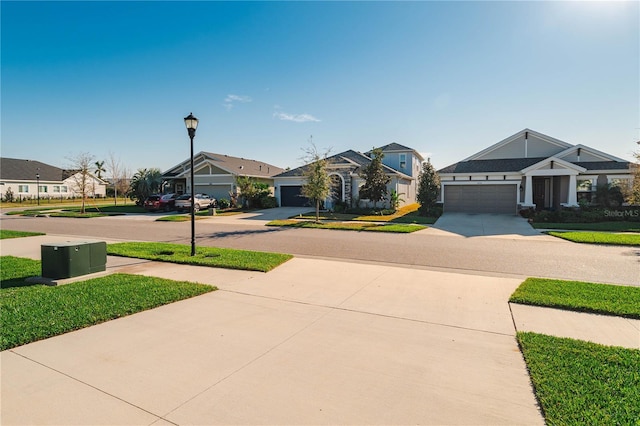 view of front of house featuring driveway, a garage, a residential view, and a front lawn