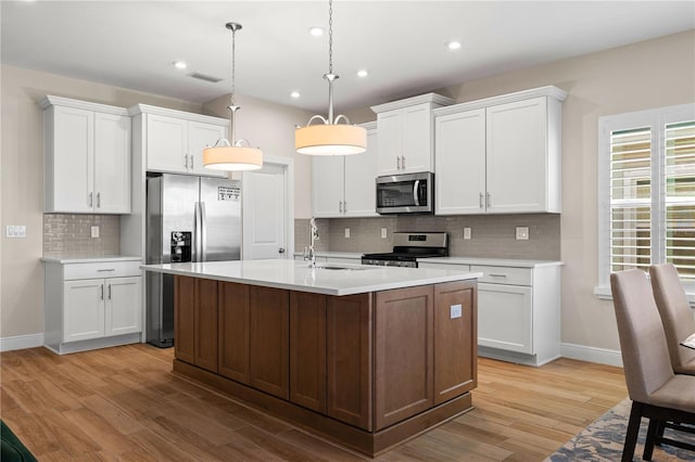 kitchen with light wood finished floors, visible vents, appliances with stainless steel finishes, and light countertops