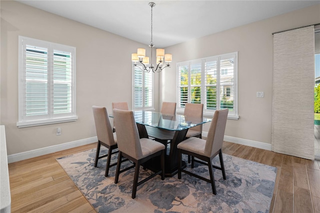 dining room with a chandelier, baseboards, and wood finished floors