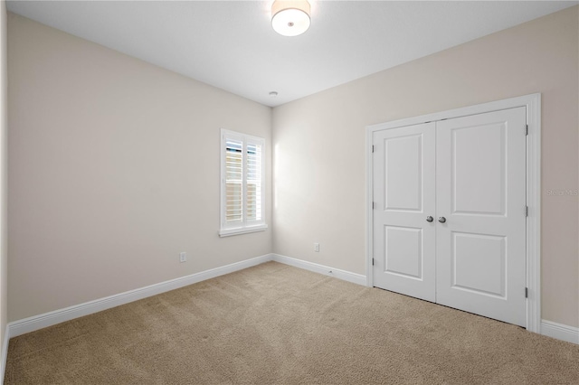 unfurnished bedroom featuring a closet, carpet flooring, and baseboards