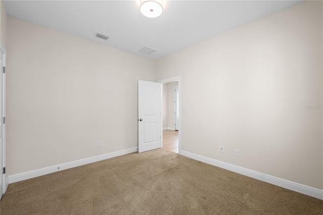 unfurnished room featuring carpet floors, visible vents, and baseboards