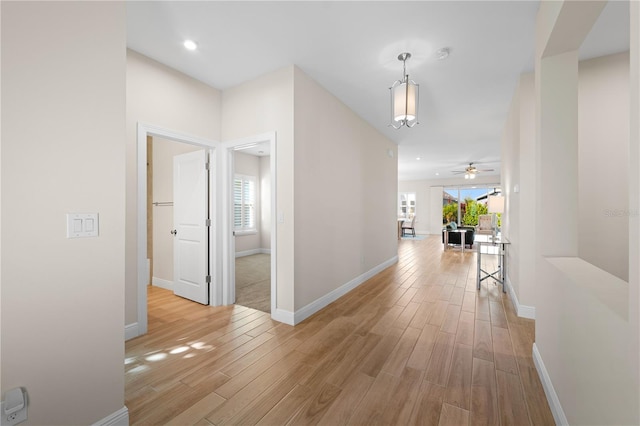 corridor with recessed lighting, light wood-style flooring, and baseboards