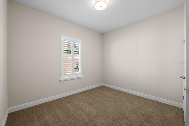 carpeted spare room featuring baseboards