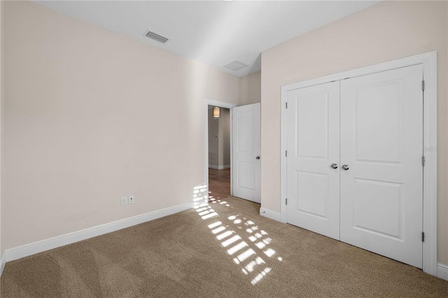 unfurnished bedroom featuring a closet, carpet flooring, visible vents, and baseboards