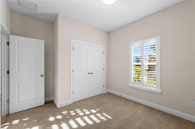 unfurnished bedroom featuring a closet, carpet flooring, visible vents, and baseboards