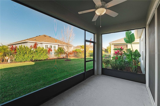 unfurnished sunroom featuring ceiling fan