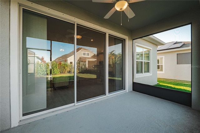 unfurnished sunroom featuring ceiling fan