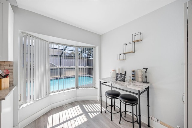 dining space featuring baseboards and light wood-style floors