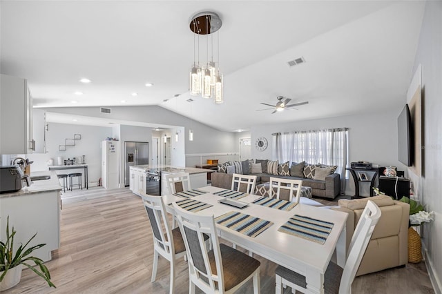 dining area featuring lofted ceiling, recessed lighting, ceiling fan with notable chandelier, visible vents, and light wood-type flooring