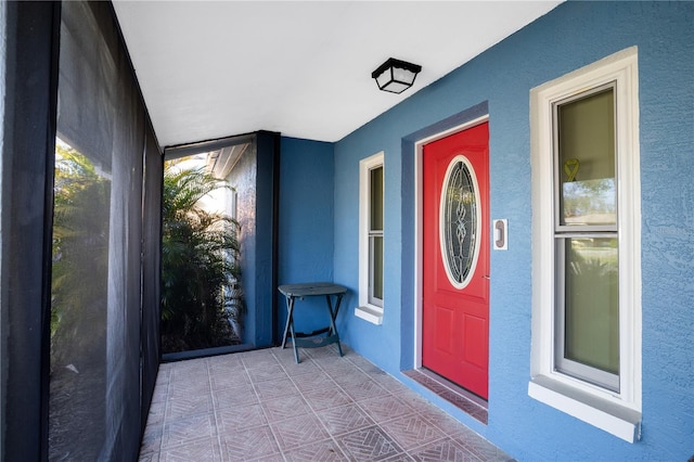 doorway to property featuring stucco siding