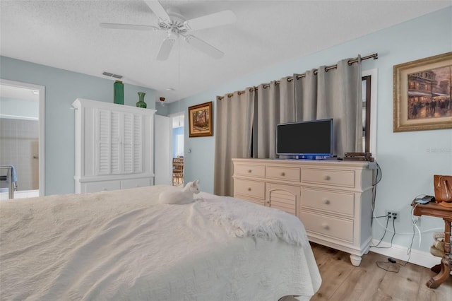 bedroom featuring visible vents, light wood-style flooring, ceiling fan, a textured ceiling, and baseboards