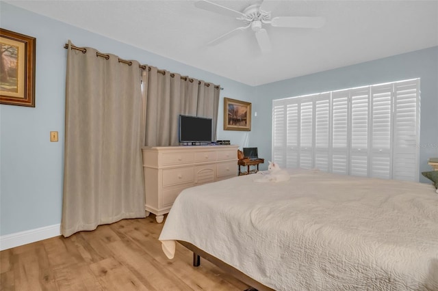 bedroom featuring ceiling fan, light wood-style flooring, and baseboards