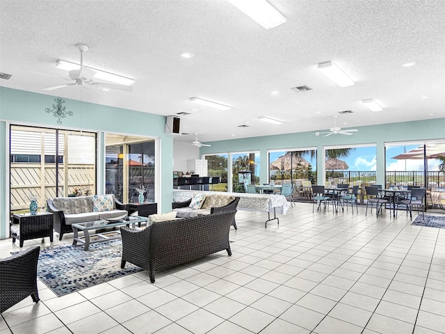 living room with light tile patterned floors, ceiling fan, and visible vents