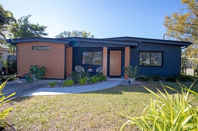 mid-century modern home featuring a front lawn