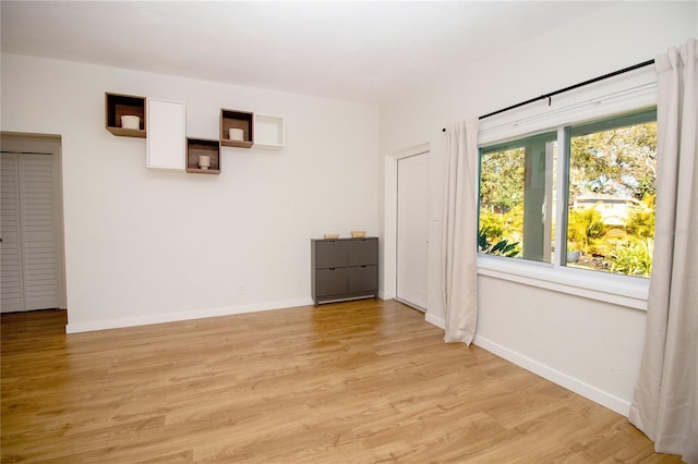 unfurnished room featuring light wood-style flooring and baseboards