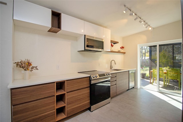 kitchen with white cabinets, modern cabinets, stainless steel appliances, open shelves, and a sink