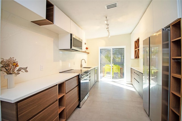 kitchen with tasteful backsplash, visible vents, modern cabinets, appliances with stainless steel finishes, and open shelves