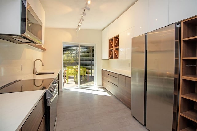 kitchen with stainless steel appliances, modern cabinets, a sink, and open shelves