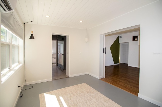 empty room featuring baseboards, wooden ceiling, concrete flooring, an AC wall unit, and recessed lighting